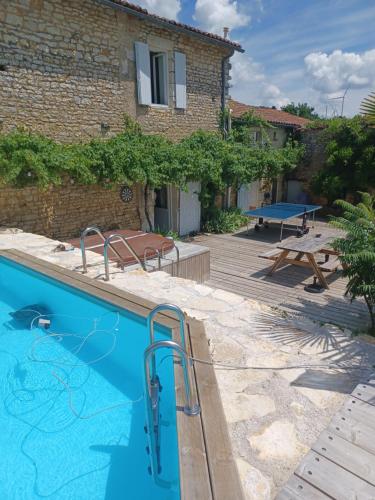 uma casa com piscina e mesa de piquenique em Nid Charentais Angouleme pool jacuzzi em La Poterie