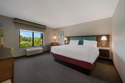 a hotel room with a large bed and a window at Hampton Inn by Hilton Detroit Southfield in Southfield