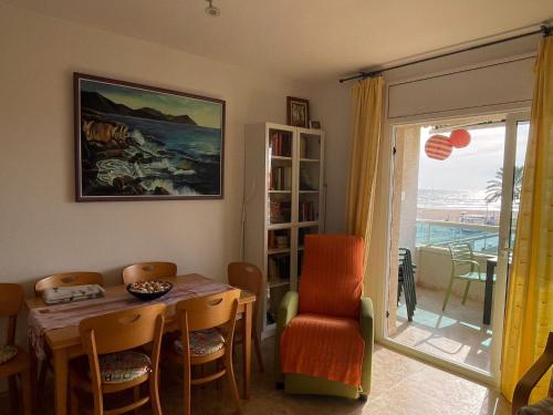 comedor con mesa, sillas y ventana en Cunit Beach, en Cunit