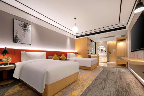 a hotel room with two beds and a kitchen at Hilton Garden Inn Changsha Yuelu in Changsha
