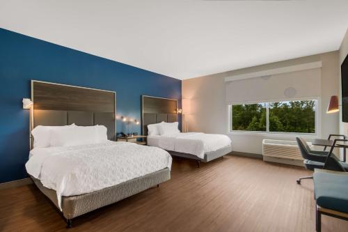 a bedroom with two beds and a blue wall at Tru By Hilton Wilson in Wilson