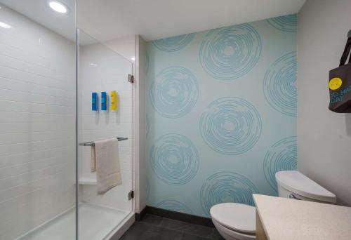 a bathroom with a shower and a toilet and a tub at Tru By Hilton Novi Detroit in Novi