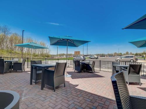 a patio with tables and chairs with umbrellas at Hampton Inn & Suites Williamstown Ark Encounter, Ky in Williamstown