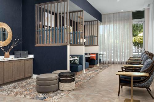 a lobby with a row of chairs and blue walls at Hampton Inn Delray Beach in Delray Beach