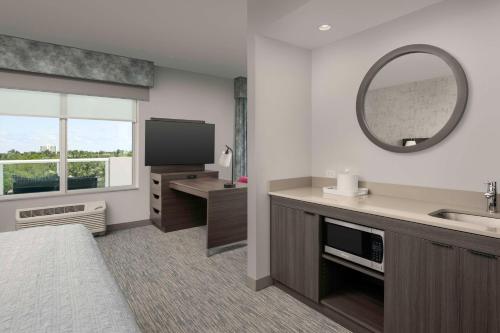 a hotel room with a sink and a mirror at Hampton Inn Delray Beach in Delray Beach