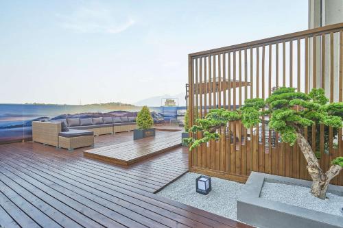 a deck with a couch and a tree on it at Hilton Garden Inn Chenzhou Beihu in Chenzhou