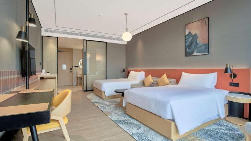 a hotel room with two beds and a desk at Hilton Garden Inn Chenzhou Beihu in Chenzhou