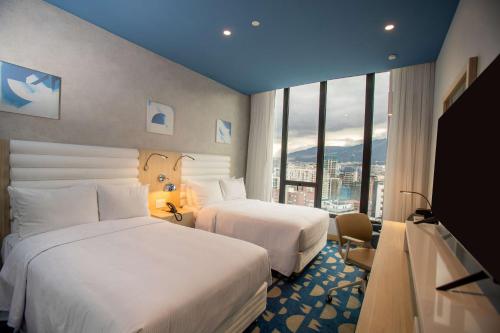 a hotel room with two beds and a large window at Hampton By Hilton Quito La Carolina Park in Quito