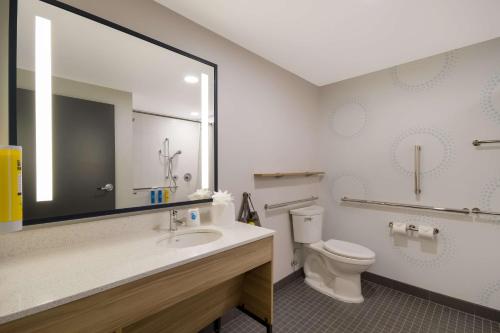 W łazience znajduje się toaleta, umywalka i lustro. w obiekcie Tru By Hilton Destin w mieście Destin