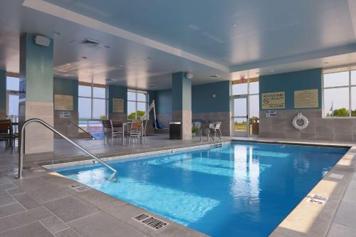 - une grande piscine d'eau bleue dans un bâtiment dans l'établissement Hampton Inn & Suites Manistee, Mi, à Manistee