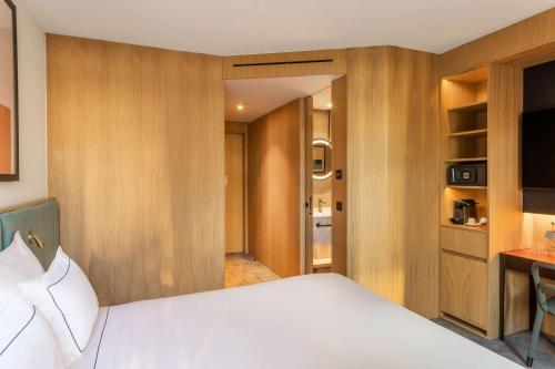 a bedroom with a white bed and wooden walls at Arts Hotel Porto, Tapestry Collection By Hilton in Porto
