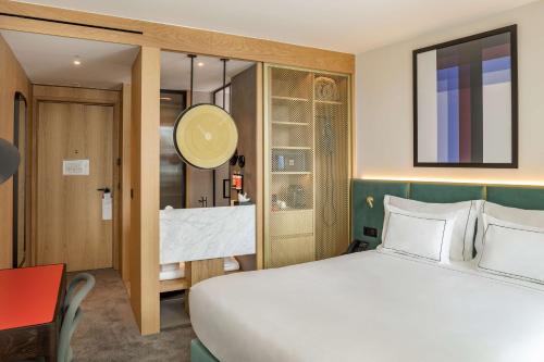 1 dormitorio con 1 cama blanca grande y escritorio en Arts Hotel Porto, Tapestry Collection By Hilton, en Oporto