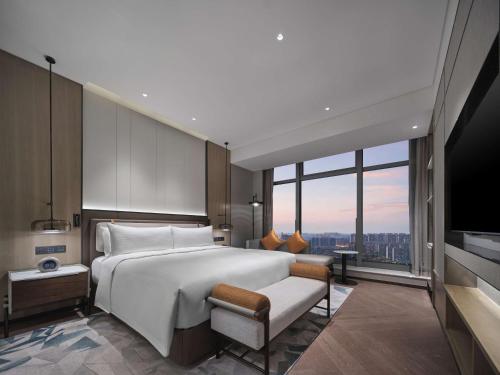 a bedroom with a large white bed and a large window at Doubletree By Hilton Rugao in Rugao