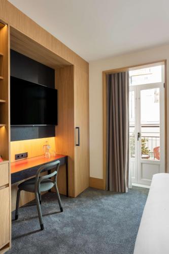 a hotel room with a desk and a tv at Arts Hotel Porto, Tapestry Collection By Hilton in Porto