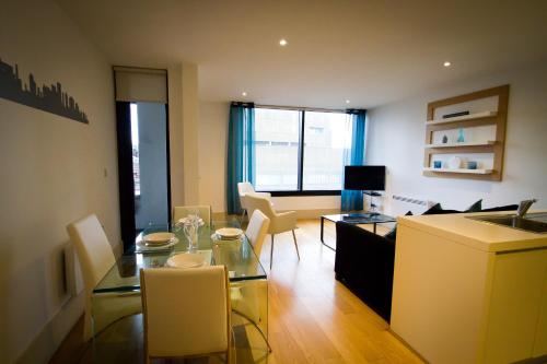 a living room with a glass table and chairs at Merchant Quarters Apartments in Liverpool