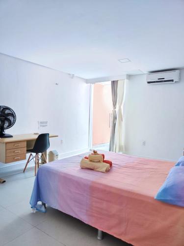 a bedroom with a large bed with a pink blanket at Casa Sagrada 282 in Fortaleza