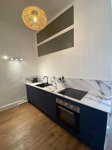 une cuisine avec un évier et un plan de travail dans l'établissement Superbe T3 neuf centre-ville, à Nîmes