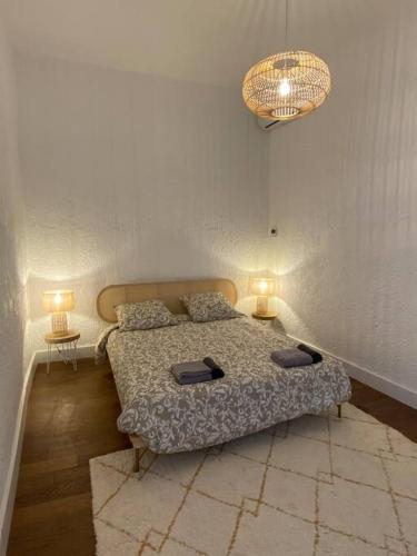- une chambre avec un lit et deux lampes sur deux tables dans l'établissement Superbe T3 neuf centre-ville, à Nîmes