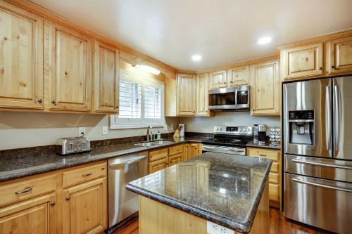 a kitchen with wooden cabinets and stainless steel appliances at Updated Ranch Apartment with Deck - 9 Mi to Downtown in Taylorsville