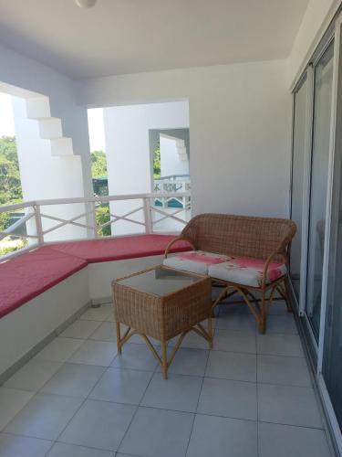 a balcony with a bed and a chair and a table at Tropical Optimal Tropicana Sur in Sosúa
