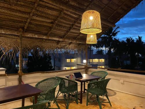 瓦卡拉的住宿－Native by Cliff and Coral，一个带桌椅和吊灯的庭院
