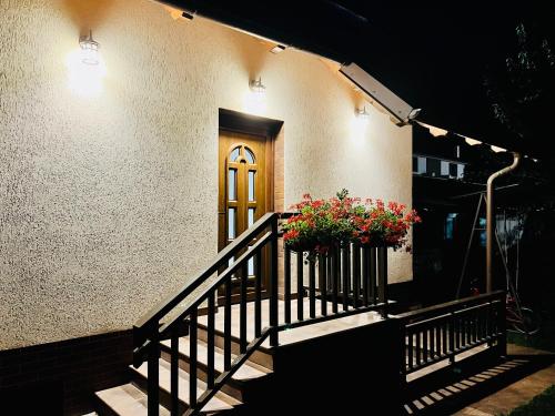 a house with a door and a porch with flowers at Altheda Living Tiny House in Suceava