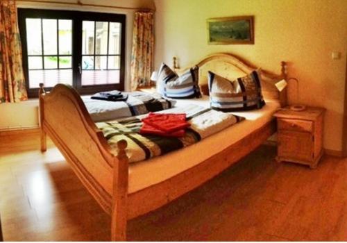 1 dormitorio con 1 cama grande de madera con almohadas. en Blaues Haus Neu Reddevitz, en Lancken-Granitz