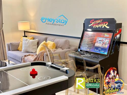 a living room with a table with a laptop computer on it at The Apple Residence By Heystay Management in Melaka