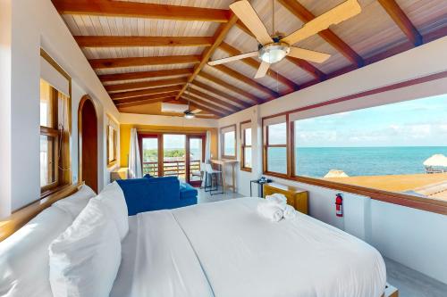 a bedroom with a large bed and a view of the ocean at Beachfront Villa Island Pearl Gold Standard Certified in Caye Caulker