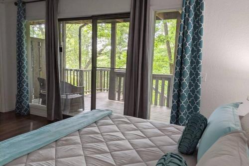 a bedroom with a bed and a balcony with sliding glass doors at Lakeside Trail in Bella Vista