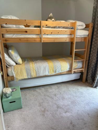 a bunk bed with a wooden bunk bed frame at Campion Cottage in Brixham