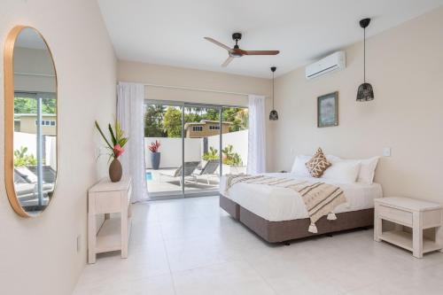 a bedroom with a bed and a mirror at Villa Varia in Rarotonga