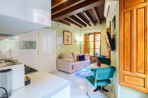 een keuken en woonkamer met een tafel en een bank bij Aile Granada - Hostatel in Granada
