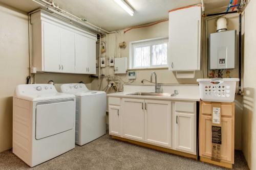uma pequena cozinha com electrodomésticos brancos e um lavatório em Charming Cherry Creek Duplex 3 Mi to Zoo! em Denver