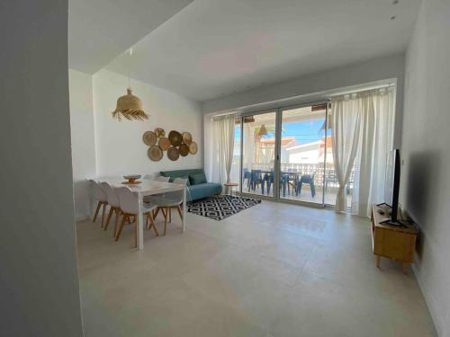 ein weißes Wohnzimmer mit einem Tisch und einem TV in der Unterkunft Apartamento Maria Benlliure in Bellreguart