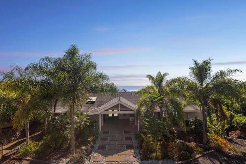 dom z palmami przed nim w obiekcie Pu'ukala Sunset Estate with Amazing Ocean Views! home w mieście Kailua-Kona