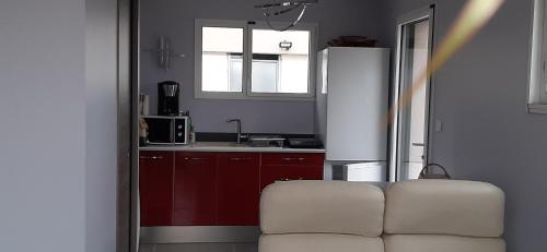a living room with a white couch in a kitchen at Studio indépendant de 28 m2, avec vue magnifique. in Civrieux-dʼAzergues