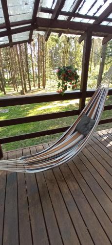 a hammock on a deck in a pergola at Domek na Mazurach Leśne Zacisze in Ostaszewo