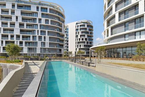 an empty swimming pool in front of two tall buildings at Ellipse Waterfall 31002 in Midrand
