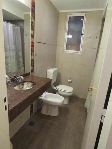 a bathroom with a toilet and a sink at Grand Hotel in Reconquista