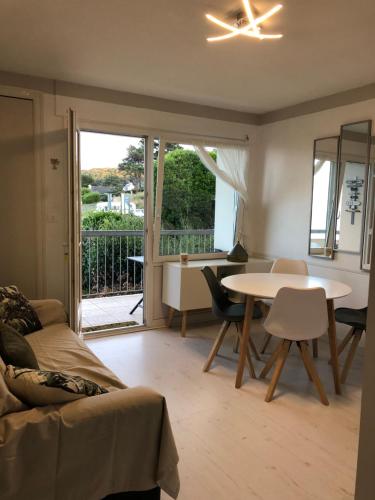 ein Wohnzimmer mit einer Couch und einem Tisch mit Stühlen in der Unterkunft T2 Vue MER COSY HORIZON PLAGE in Plérin