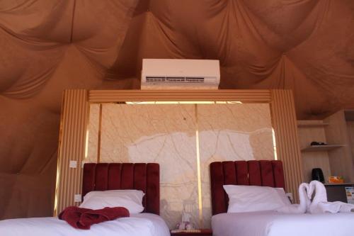 two beds in a room with a tent at Yara camp in Wadi Rum