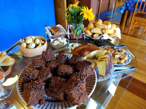 a table topped with different types of bread and pastries at Pousada Vivenda in Tiradentes