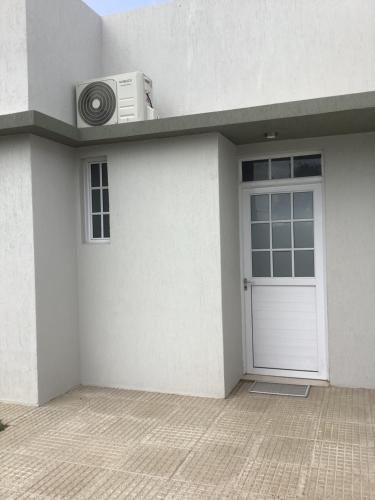 a white house with a door and a air conditioner at Los Olivos in Federación