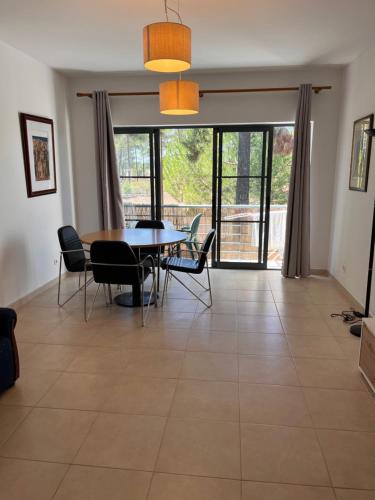 a dining room with a table and chairs on a tile floor at Pinhos Residence Palmela Village in Quinta do Anjo