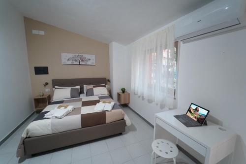 1 dormitorio con 1 cama y escritorio con ordenador portátil en Cerchia Apartments, en Corbara