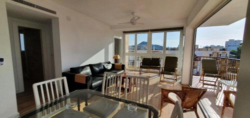 un soggiorno con divano e tavolo in vetro di Balcón Playa Delicias ad Águilas