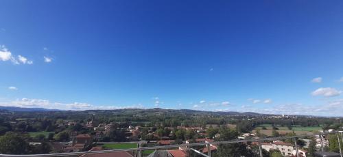 a view of a city with a blue sky at Studio indépendant de 28 m2, avec vue magnifique. in Civrieux-dʼAzergues