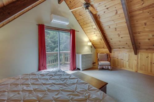 1 dormitorio con cama y ventana grande en Rustic, Cozy Cabin with Easy Ski and Beach Access!, en Bridgton