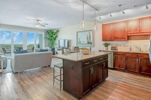 a kitchen with wooden cabinets and a living room at Laketown Wharf 834 in Panama City Beach